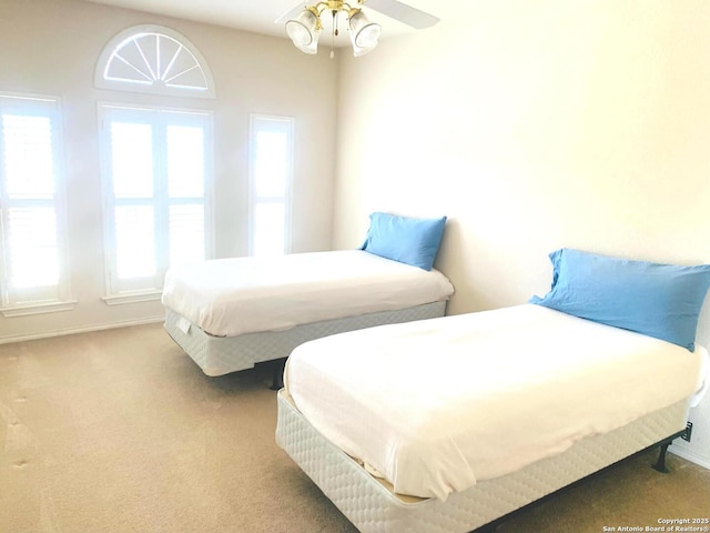 carpeted bedroom with ceiling fan and multiple windows