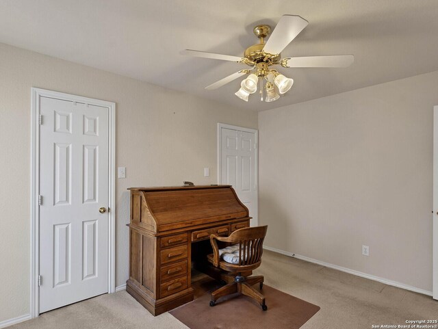 carpeted office space with ceiling fan