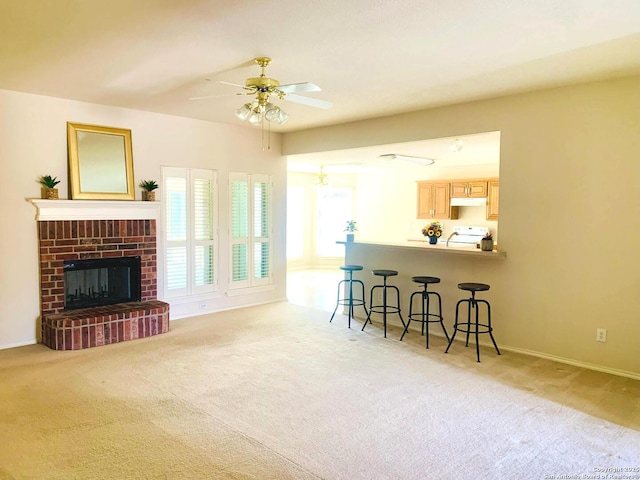 carpeted living room featuring ceiling fan and a brick fireplace