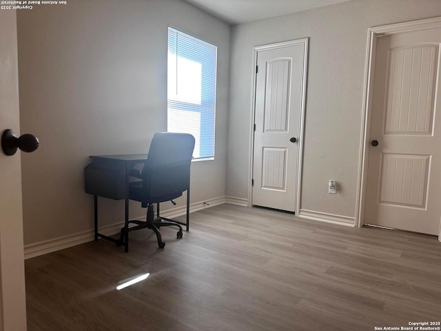 unfurnished office featuring light wood-type flooring and a wealth of natural light