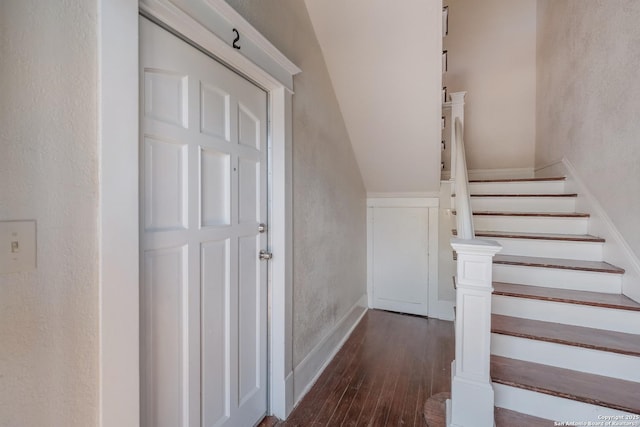 stairway with lofted ceiling and hardwood / wood-style flooring