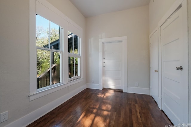 unfurnished room with dark hardwood / wood-style flooring