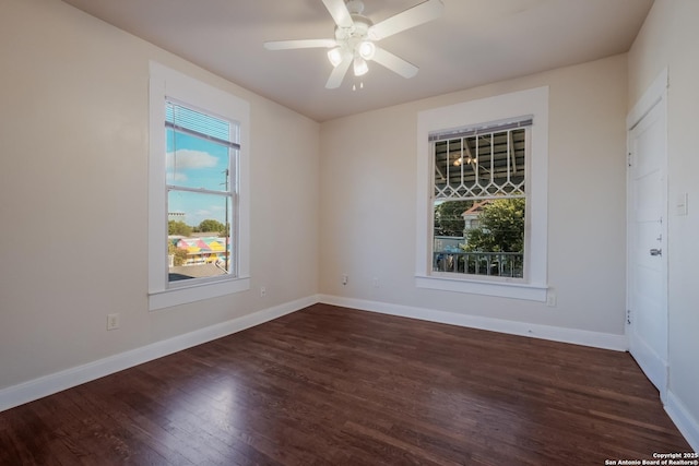 empty room featuring ceiling fan, a wealth of natural light, and dark hardwood / wood-style floors