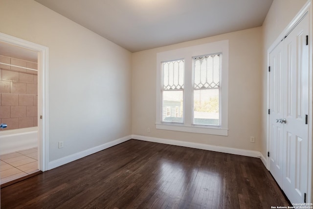 unfurnished bedroom with dark wood-type flooring