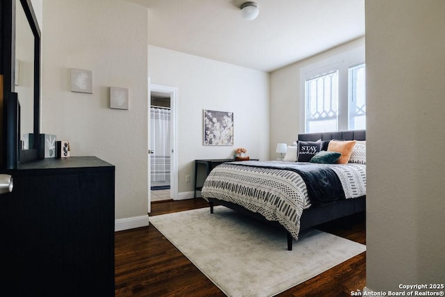 bedroom with dark hardwood / wood-style floors