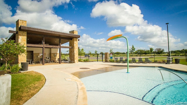 view of home's community with a pool and a patio