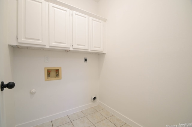 clothes washing area with cabinets, light tile patterned floors, hookup for a washing machine, and hookup for an electric dryer