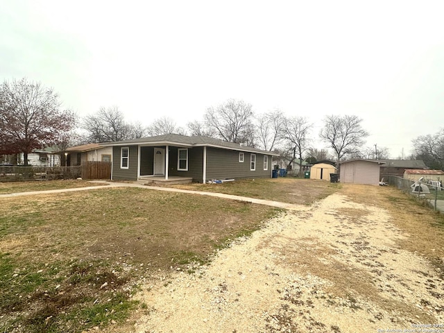 view of front of home with a storage shed and a front yard