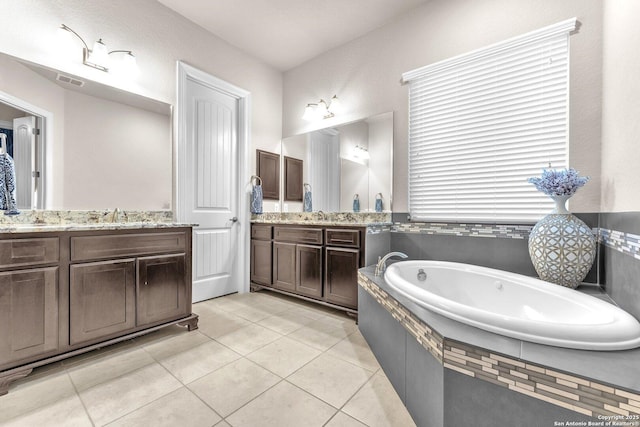 bathroom featuring tiled bath, tile patterned floors, and vanity