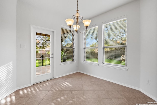 unfurnished dining area with plenty of natural light, a chandelier, and light tile patterned flooring