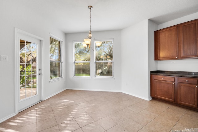 unfurnished dining area featuring an inviting chandelier and light tile patterned floors