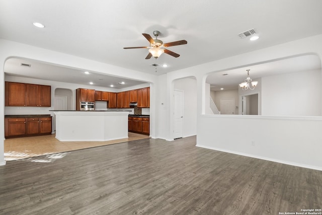 unfurnished living room with wood-type flooring and ceiling fan with notable chandelier