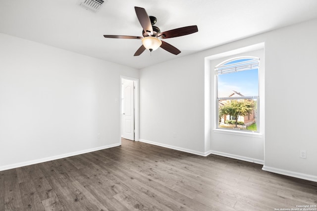 spare room with ceiling fan and dark hardwood / wood-style flooring