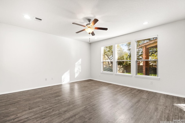 empty room featuring dark wood-type flooring and ceiling fan