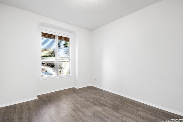 spare room with dark hardwood / wood-style flooring