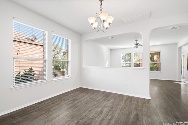 empty room with ceiling fan with notable chandelier and dark hardwood / wood-style floors