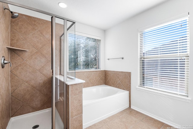 bathroom featuring tile patterned floors and separate shower and tub