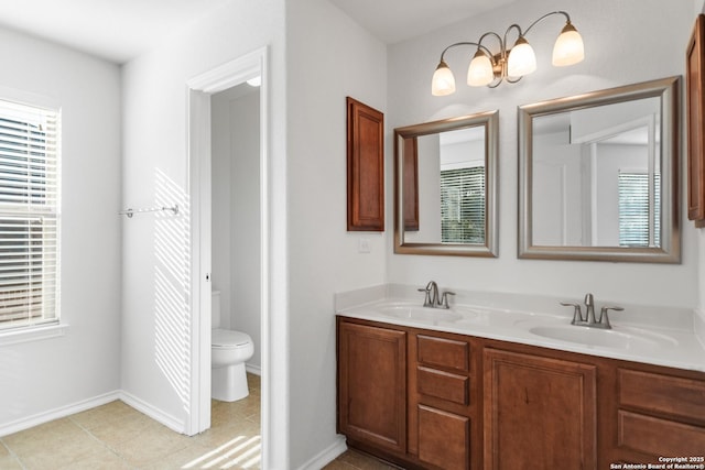 bathroom with toilet, vanity, and plenty of natural light