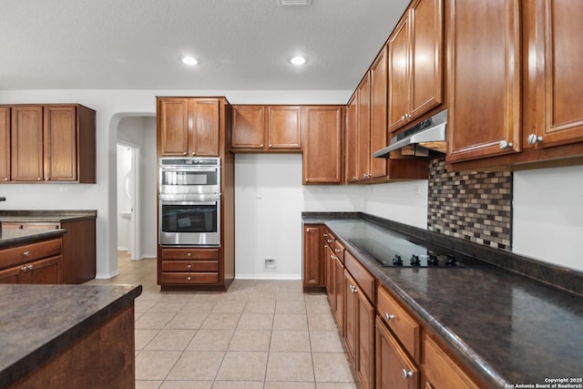 kitchen featuring light tile patterned floors, stainless steel double oven, black electric stovetop, and a textured ceiling