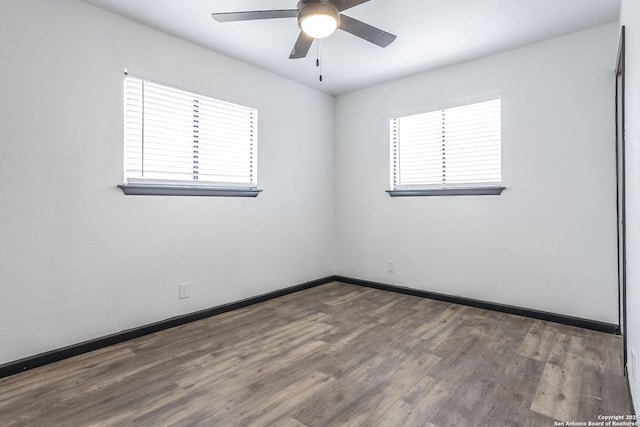 spare room with ceiling fan and dark hardwood / wood-style floors