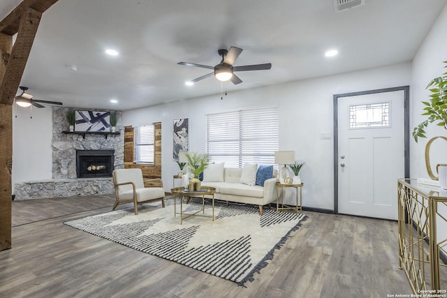 living room with ceiling fan, wood-type flooring, and a fireplace