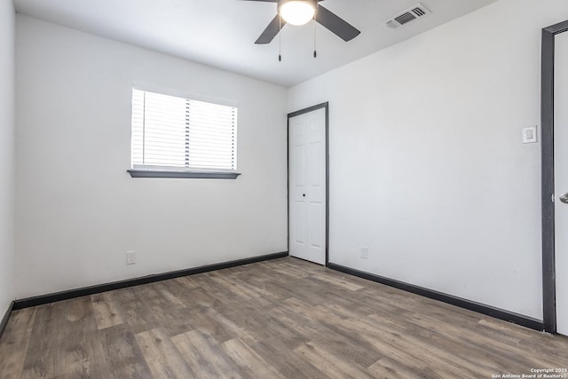 spare room with ceiling fan and wood-type flooring