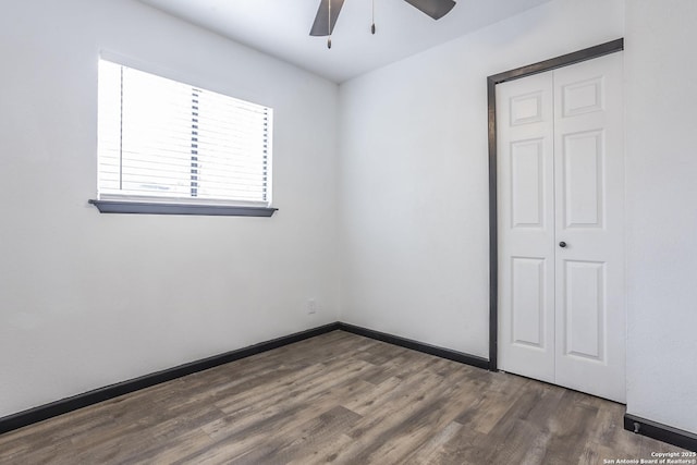 empty room featuring ceiling fan and dark hardwood / wood-style flooring