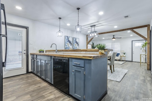 kitchen featuring pendant lighting, black dishwasher, butcher block counters, sink, and ceiling fan