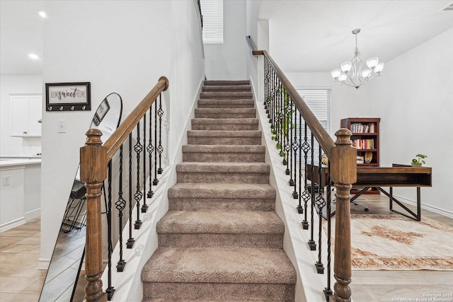 stairs featuring a chandelier