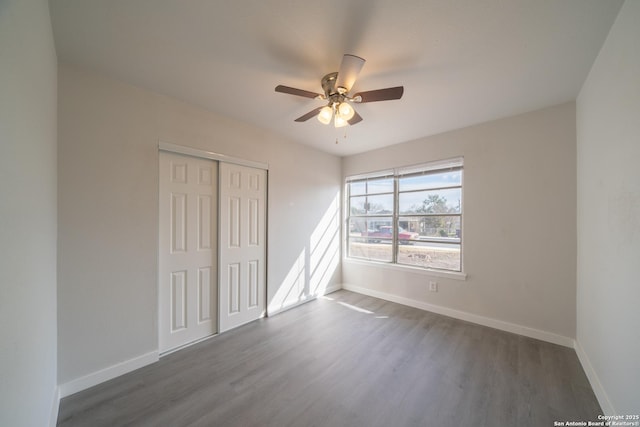 unfurnished room featuring dark wood-type flooring and ceiling fan