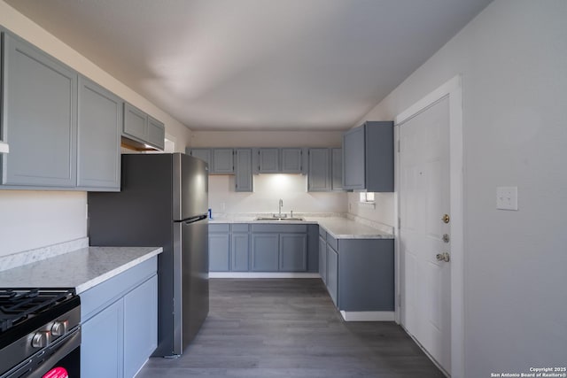 kitchen with dark wood-type flooring, appliances with stainless steel finishes, gray cabinetry, and sink