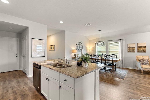 kitchen with white cabinetry, decorative light fixtures, a kitchen island with sink, stainless steel dishwasher, and sink