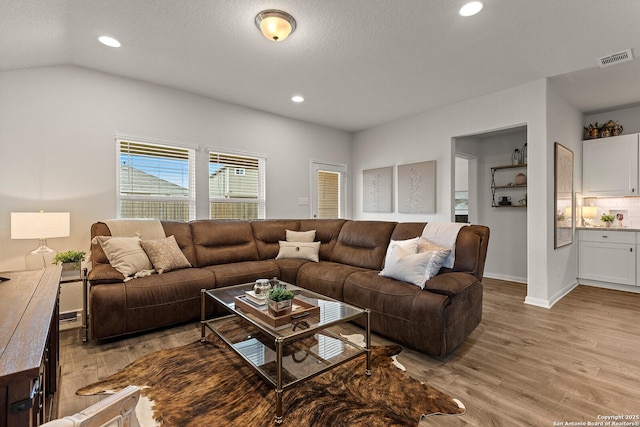 living room with lofted ceiling and light hardwood / wood-style floors