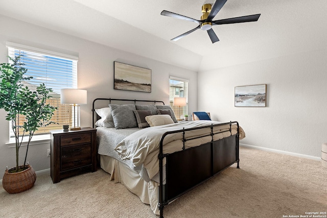 carpeted bedroom featuring lofted ceiling, ceiling fan, and multiple windows