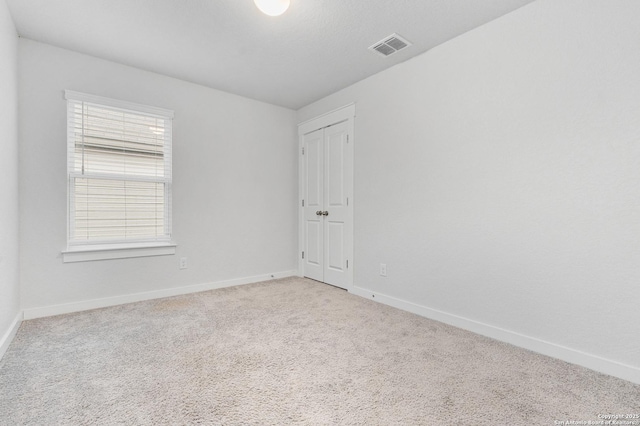 carpeted spare room featuring a wealth of natural light