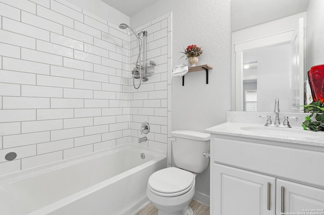 full bathroom with toilet, vanity, hardwood / wood-style floors, and tiled shower / bath