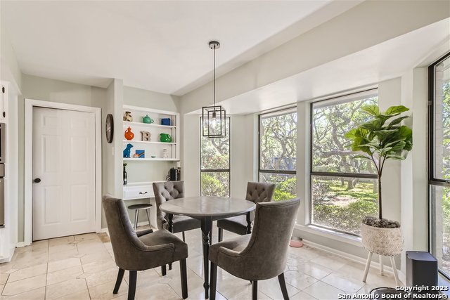 tiled dining area featuring an inviting chandelier and built in shelves