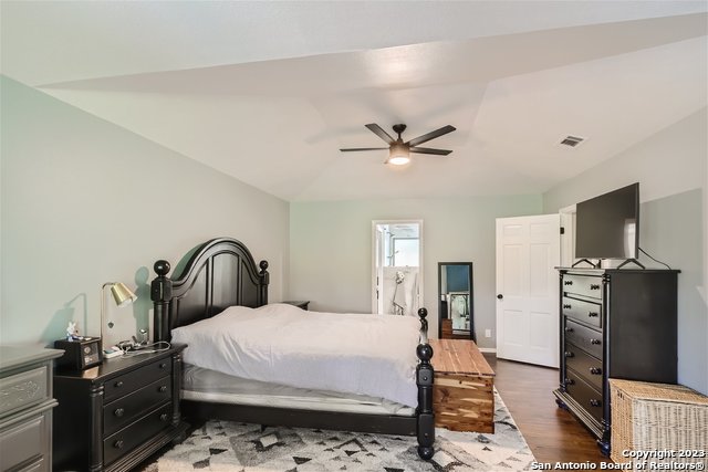 bedroom featuring ceiling fan, dark hardwood / wood-style flooring, and lofted ceiling