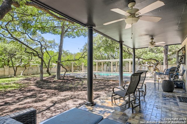 view of patio / terrace featuring ceiling fan and a fenced in pool