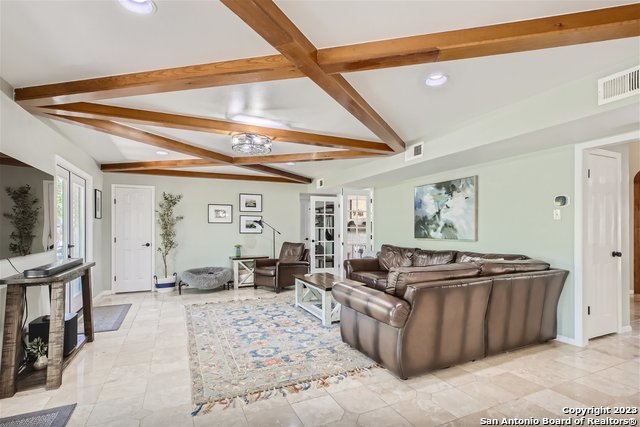 living room featuring french doors and lofted ceiling with beams