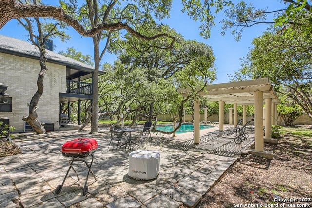 view of patio featuring a pergola and a balcony