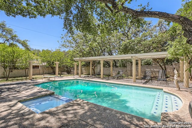 view of pool featuring a patio area and an in ground hot tub