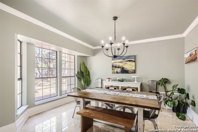 dining area featuring ornamental molding and a chandelier