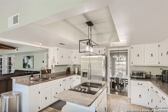 kitchen with stainless steel fridge with ice dispenser, white cabinetry, and a center island