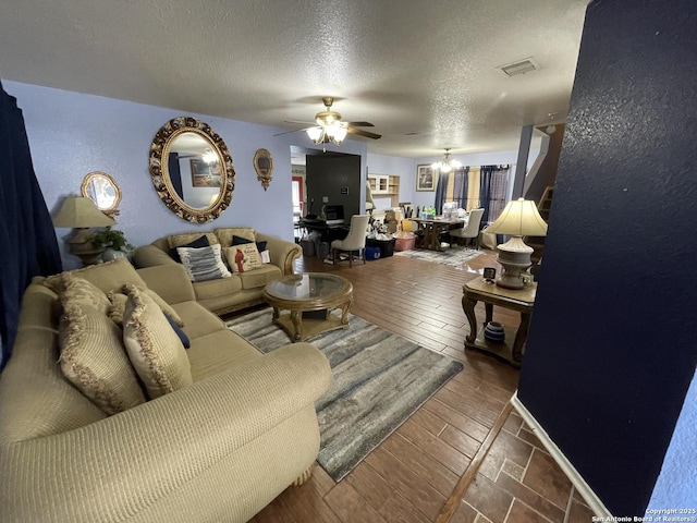 living room with a textured ceiling and ceiling fan