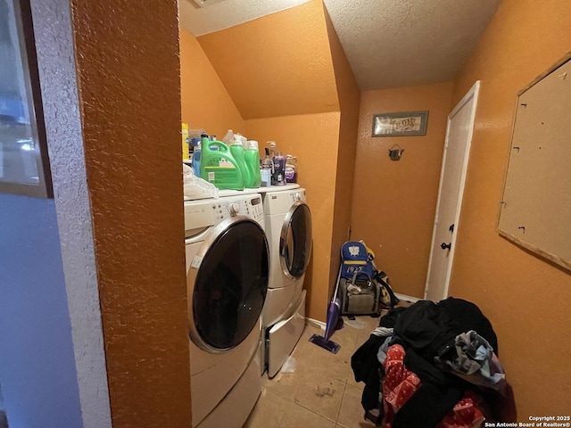 laundry area featuring light tile patterned floors, washing machine and dryer, a textured ceiling, and electric panel