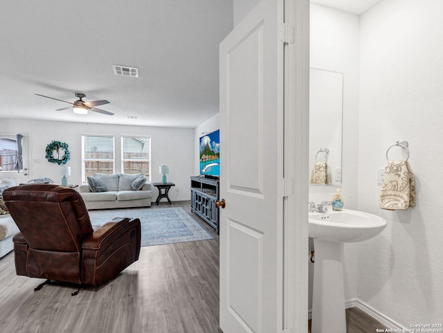 bathroom with ceiling fan and hardwood / wood-style flooring