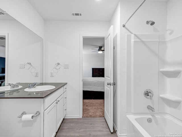 bathroom featuring ceiling fan, vanity, shower / bathtub combination, and hardwood / wood-style flooring