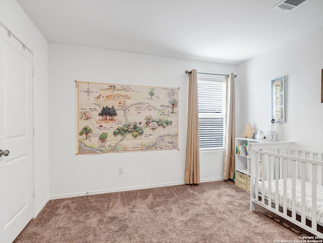 carpeted bedroom featuring a crib