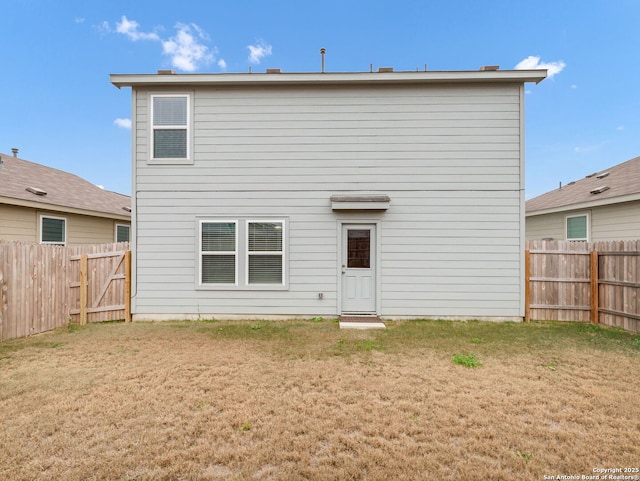 rear view of house featuring a yard